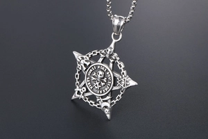 Macro detail of gothic pentagram pendant featuring skull crossbones and engraved Latin text
