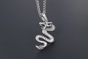 Detailed macro view of the intricate dragon pendant with fine scales and wheat chain link