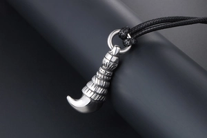 Macro detail of men's titanium steel wolf tooth pendant with retro tribal texture