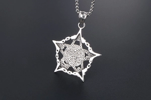 Macro shot of punk star skull embossed pendant on bead chain in silver finish