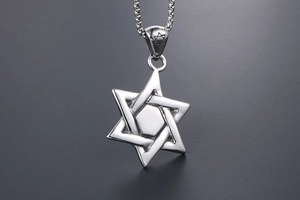 Macro shot of silver hexagram star pendant with woven lines and intricate bail engraving