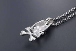 Macro view of the hollow back structure and cross chain of a punk skull pendant