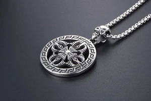 Detail of vintage silver pendant with cross rays and skull clasp on a metal box chain