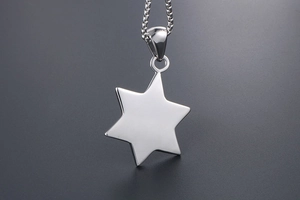 Macro detail of polished stainless steel hexagram star pendant on a square box chain