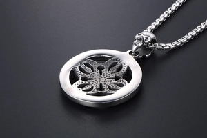 Detailed close-up of a punk-style skull connector on a stainless steel pendant necklace