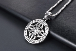 Detail of vintage silver titanium pendant featuring skull bail and geometric patterns