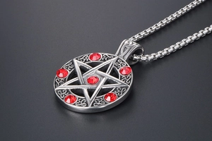 Macro view of pentagram pendant with red rhinestones and vintage engraved patterns
