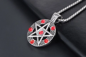 Macro shot of star pendant with red gemstones and Celtic knot patterns on box chain