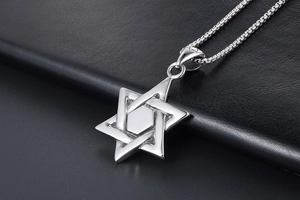 Macro shot of polished silver hexagram pendant on a sturdy box chain over leather