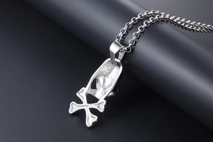 Detailed back view of vintage silver skull and crossbones pendant with steel chain