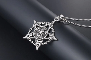 Macro detail of gothic skull and pentagram pendant with masonic symbols on box chain