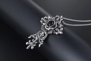 Detailed close-up of retro gothic cross pendant with black onyx and dragon relief