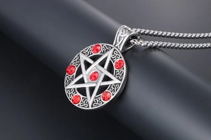 Macro view of pentagram pendant with red zircons and Celtic knots on a box chain