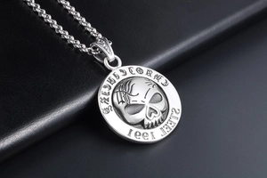 Detailed close-up of a 1991 skull pendant in stainless steel with a gothic relief design