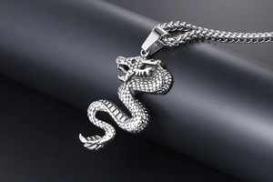 Macro view of detailed silver dragon pendant with scales texture and wheat chain
