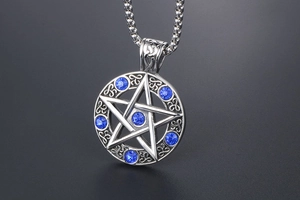 Macro shot of silver star pendant with dark blue crystals and intricate scrollwork details
