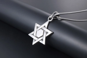 Macro detail of polished stainless steel hexagram star pendant on a heavy box chain
