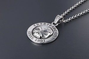 Macro side view of vintage stainless steel coin pendant with 3D skull and 1991 engraving