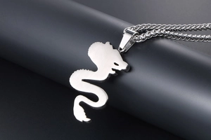 Macro detail of silver dragon pendant with brushed titanium steel finish and spiga chain