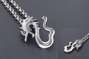 Macro view of a polished silver dragon pendant necklace with a sleek rolo chain design