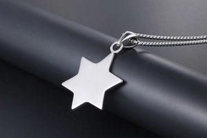 Macro detail of polished stainless steel hexagram pendant with sleek beaded necklace chain