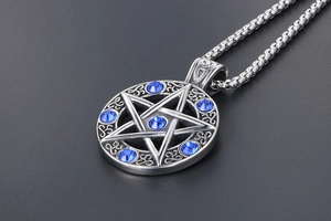 Macro view of vintage star pendant featuring blue crystals and Celtic knot engraving