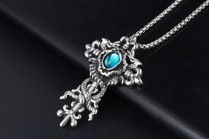 Detail of gothic cross pendant with blue gemstone and dragon engraving on leather