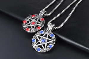 Detailed macro view of gothic pentagram pendants with red and blue faceted gemstones