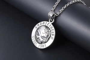Macro shot of vintage 1991 skull pendant in stainless steel with textured engraving