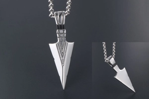 Detailed macro view of silver triangle arrow pendant with polished geometric engraved surface