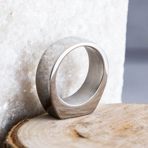Close-up of a men's titanium steel ring with a rectangular gray textured stone inlay