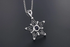 Détail d'un pendentif étoile vintage en grès bleu avec croix gravée sur l'attache en métal