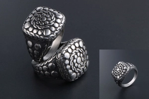 Macro detail of retro square titanium steel ring with embossed pebble texture patterns