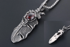 Macro view of vintage titanium steel feather pendant with deep red ruby gemstone
