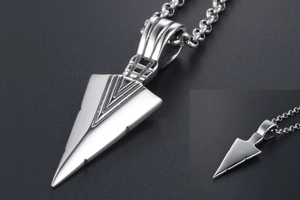 Detailed view of silver triangular arrowhead pendant with textured geometric engraving
