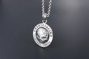 Macro detail of vintage 1991 skull pendant with engraved lettering on polished steel