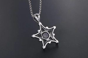 Vue macro d'un pendentif étoile vintage en acier titane avec pierre de sable bleu ronde