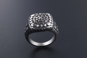 Macro shot of vintage titanium steel ring showing square cobblestone textures and carvings