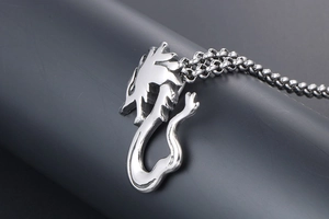 Macro detail of a silver dragon pendant necklace with polished stainless steel finish