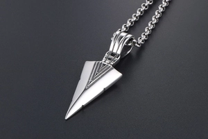 Macro detail of a silver triangular arrow pendant and stainless steel chain necklace