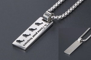 Macro shot of silver rectangular pendant with whale cutouts and Je t'aime engraving