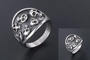 Macro detail of men's stainless steel ring featuring multiple embossed skull patterns