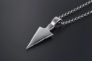 Macro detail of polished stainless steel arrow pendant with high-gloss mirror finish
