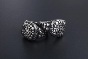 Macro view of vintage titanium steel rings with spiral cobblestone texture and braided edges