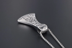 Macro view of Viking axe pendant with intricate Nordic engravings on stainless steel box chain