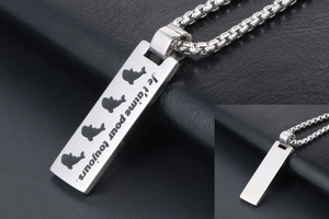 Macro detail of stainless steel dog tag necklace with dolphin pattern and French engraving