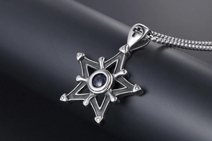 Macro d'un pendentif hexagramme vintage en acier avec grès bleu et chaîne à billes