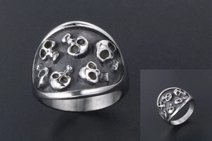 Detailed relief of vintage skull carvings on a wide stainless steel punk ring