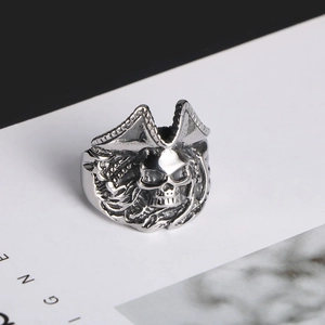 Macro detail of vintage silver pirate skull ring showing textured bones and aged steel finish