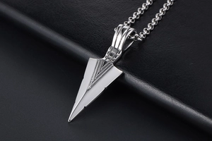 Macro shot of silver triangle arrowhead pendant with geometric V-groove details